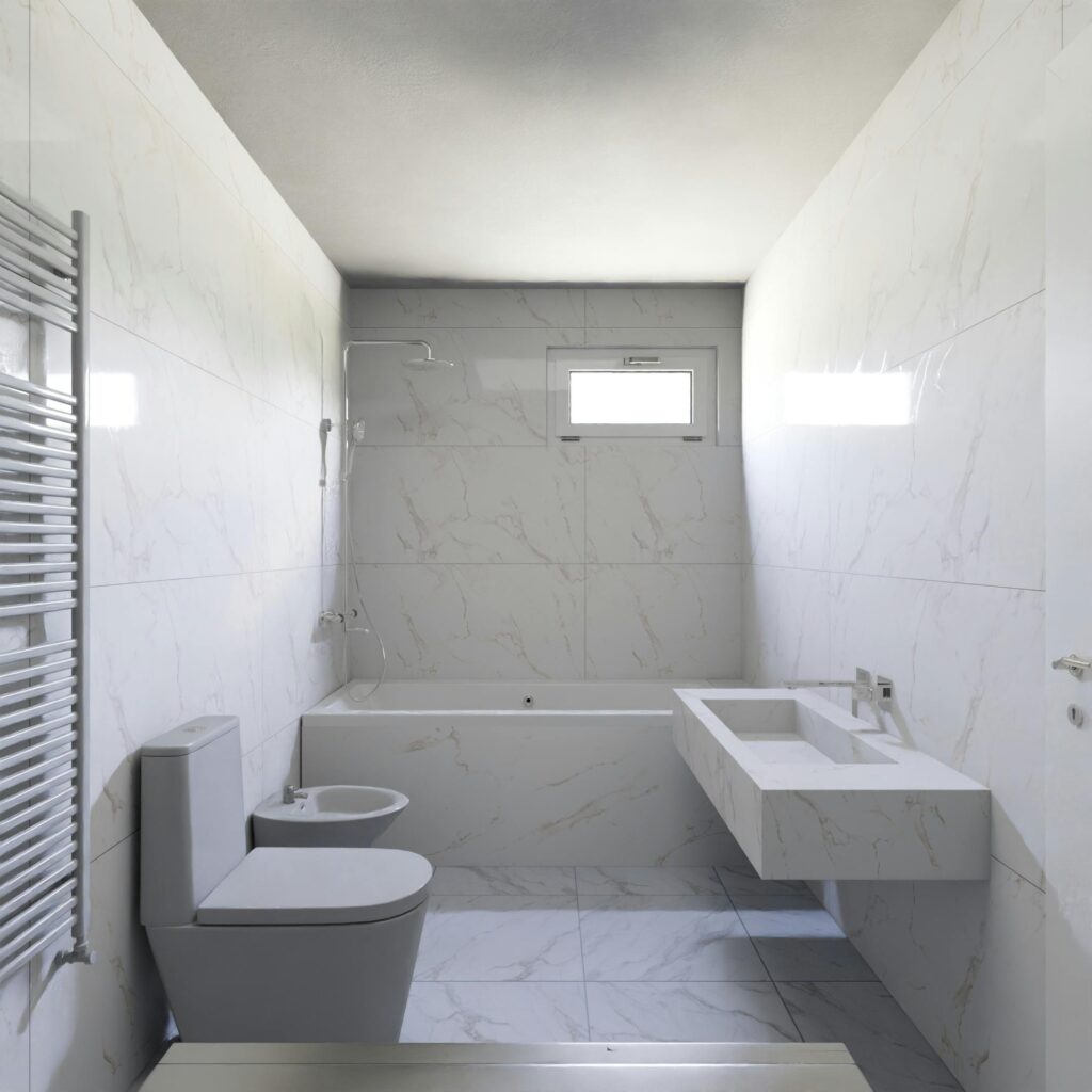 Bright white minimalist bathroom featuring modern fixtures and marble tiles.