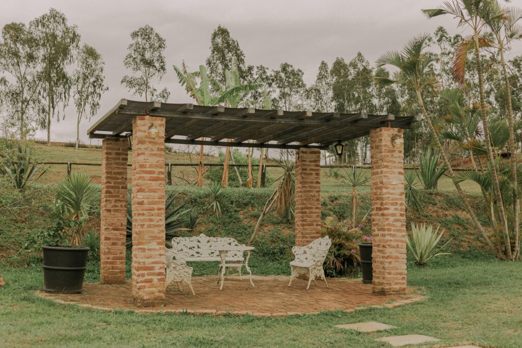 Rustic pergola with white furniture surrounded by greenery in Presidente Prudente, Brazil.