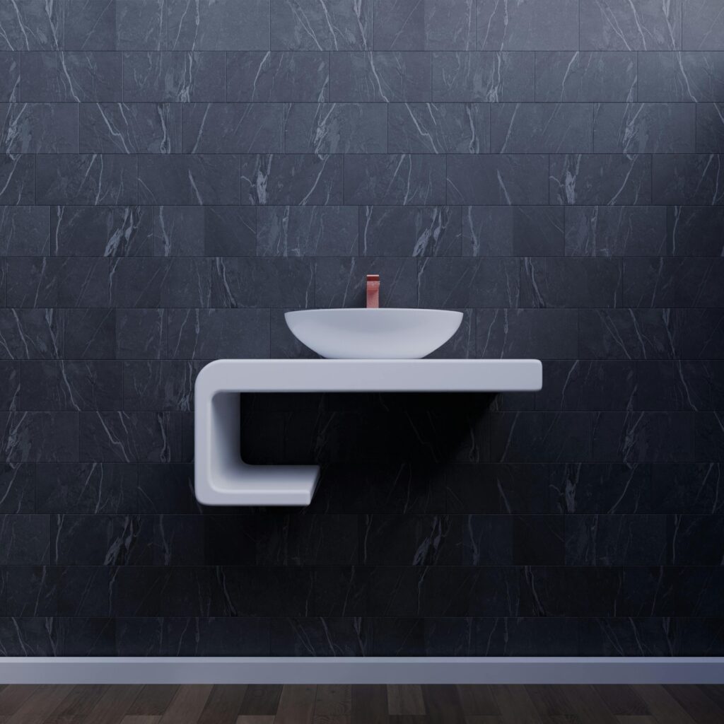 Elegant modern bathroom sink with sleek minimalist design against dark wall tiles.